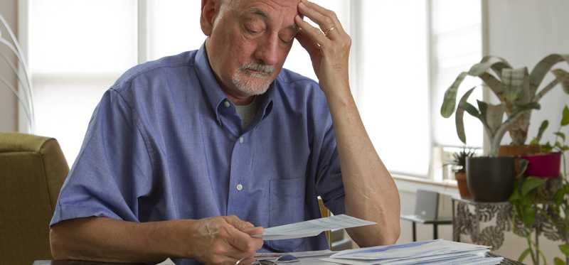 Senior man looking at bills worried