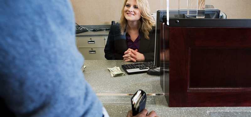 A bank teller smiling at a customer.