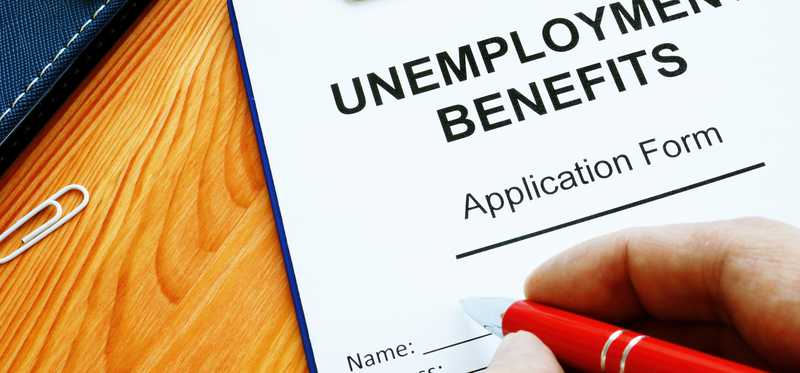 Person filling out unemployment benefits application form