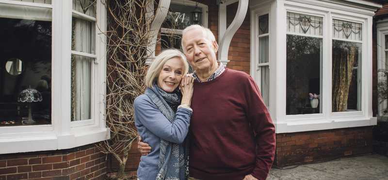 Couple standing in front of a lovely building.