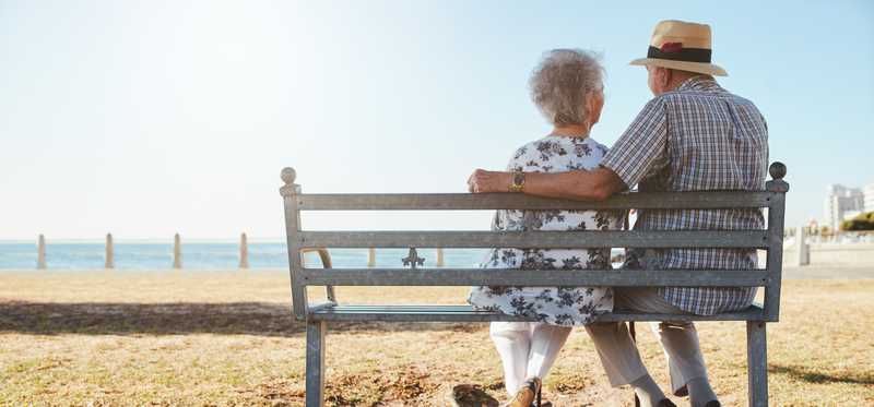 Two people sitting on a bench.