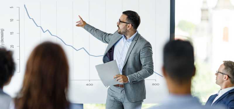 Businessperson giving presentation at meeting.