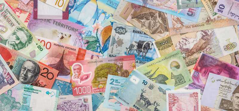 A pile of multicolored international currencies.