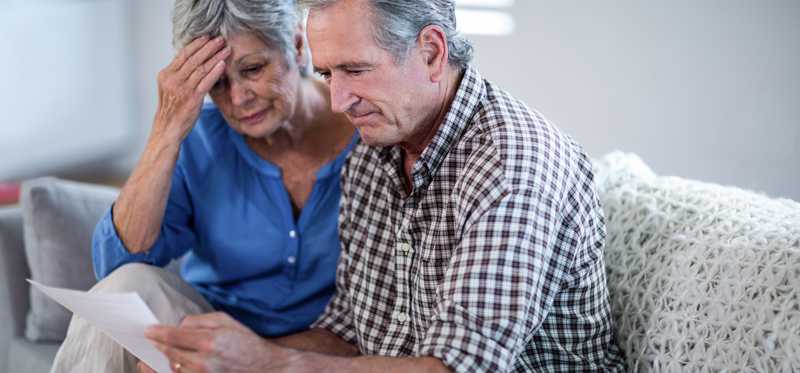 Worried older couple looking at documents