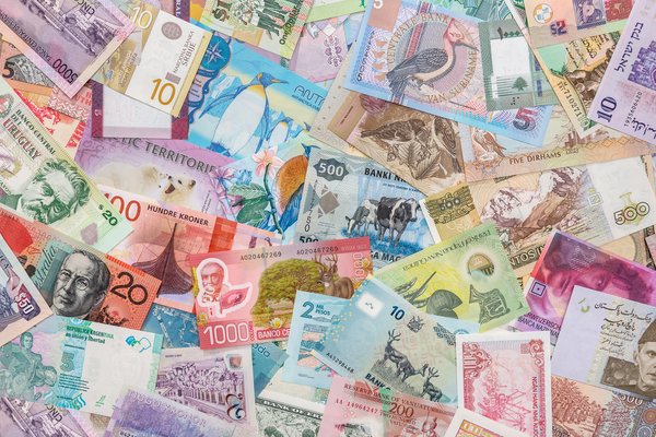 A pile of multicolored international currencies.