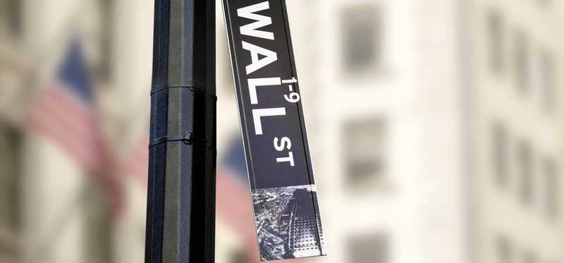 Wall Street sign hangs fallen from street post