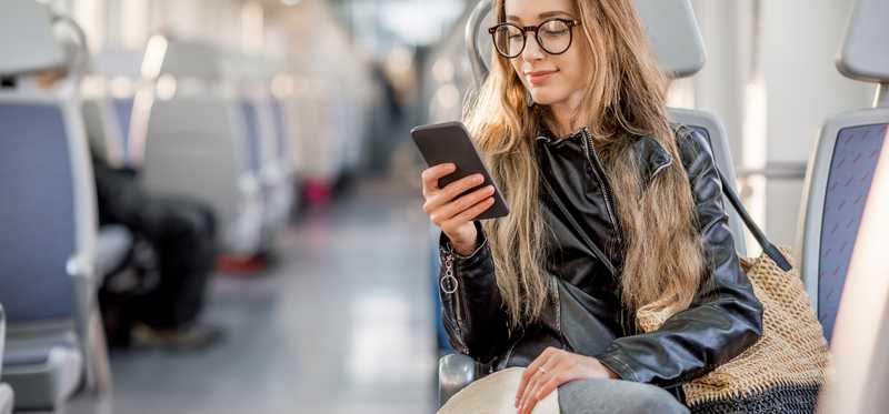 Woman on her phone sitting on the train.
