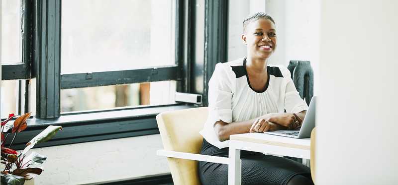 Smiling businessperson in brightly lit office.