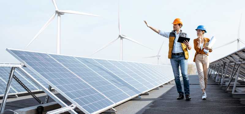 Two workers with hard hats at solar power plant.