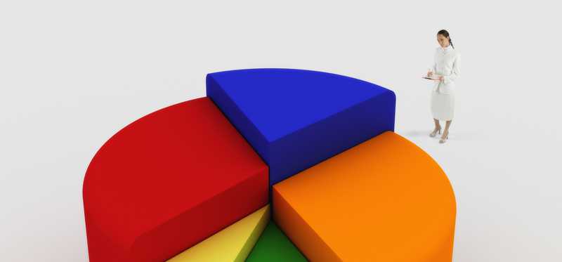 Person standing near much larger 3D colorful pie chart.