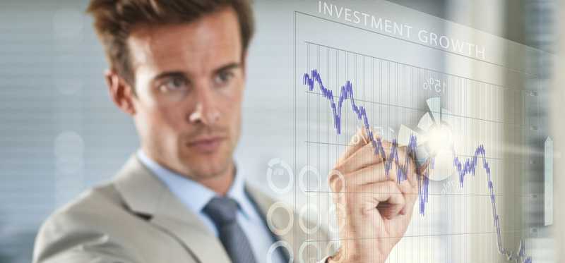 Businessman marking out stock chart patterns on wall