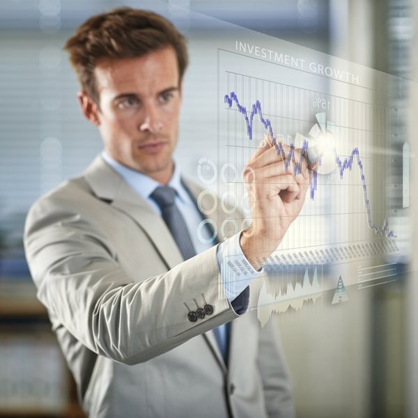 Businessman marking out stock chart patterns on wall