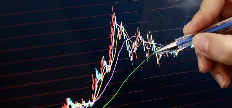 Person drawing market shifts and corrections on chart.