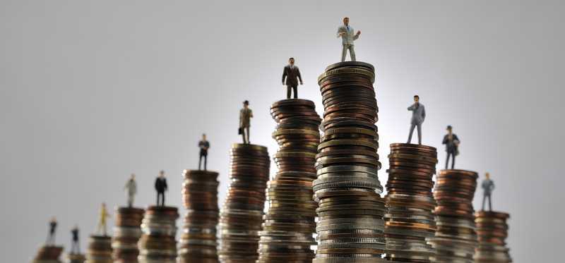 Small figurines of people on top of stacks of coins