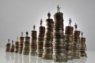 Small figurines of people on top of stacks of coins