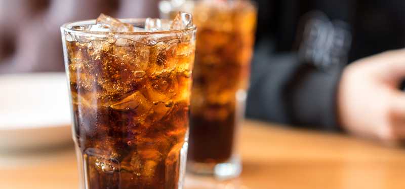 Two glasses of soda on wooden table