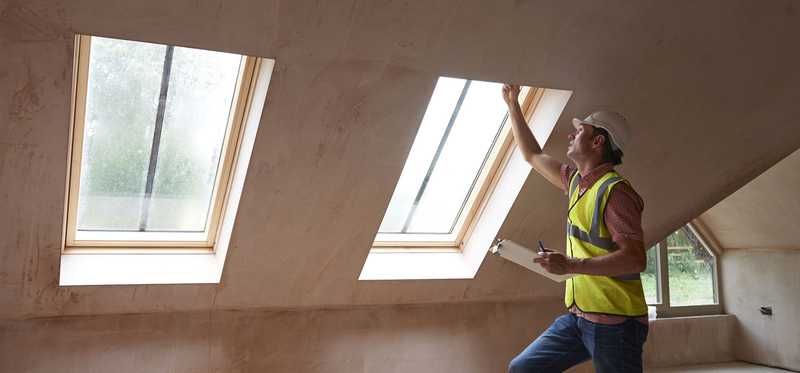 Man inspects skylights.