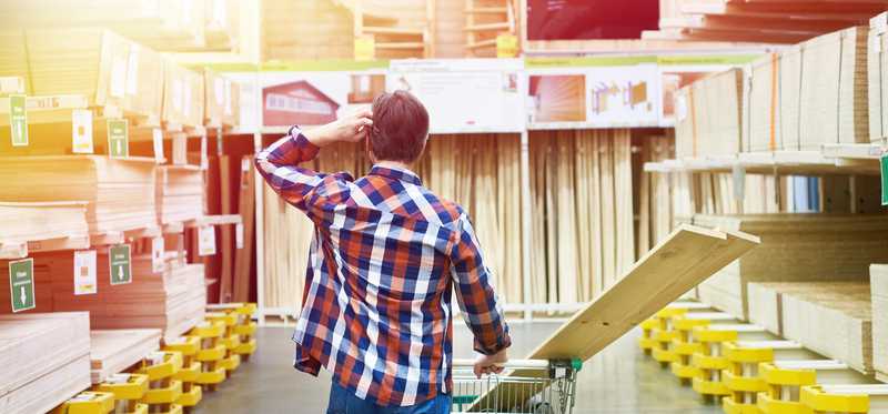 Man in hardware store shopping for lumber.