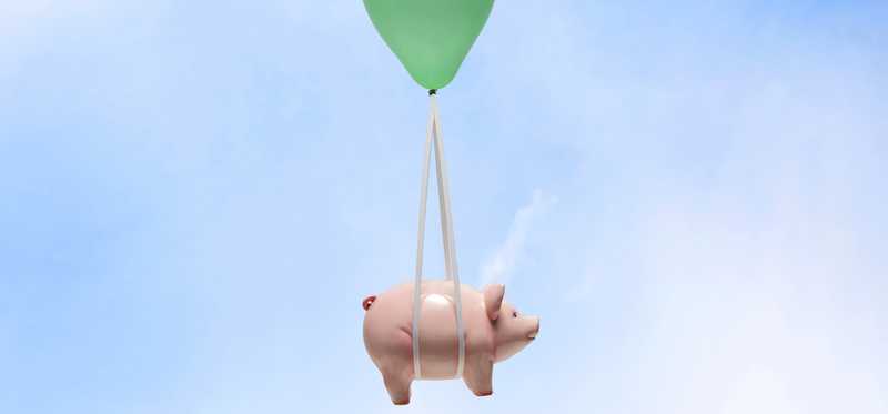 Piggy bank floating in the sky tethered to a green balloon