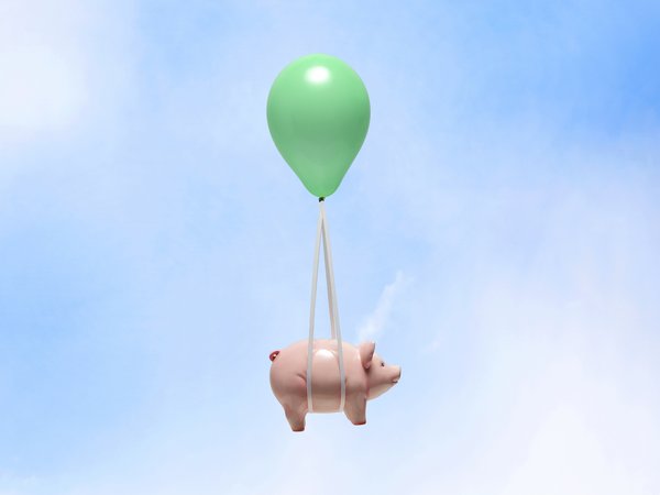 Piggy bank floating in the sky tethered to a green balloon
