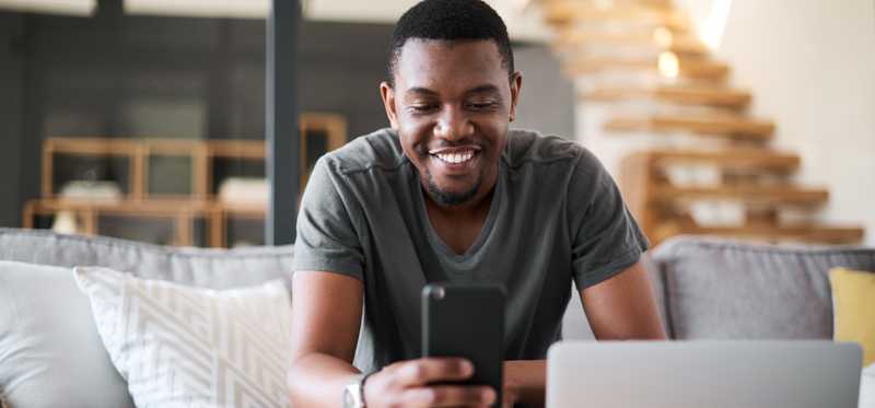 Person smiling while looking at phone.