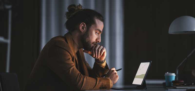 Person looking at computer screen in dark room.
