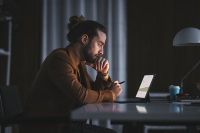 Person looking at computer screen in dark room.