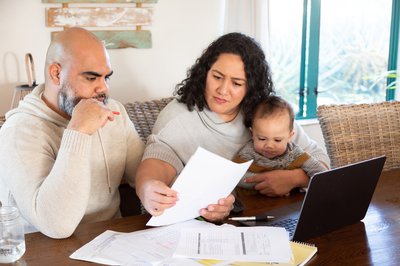 Adults sitting with baby while reviewing paperwork.