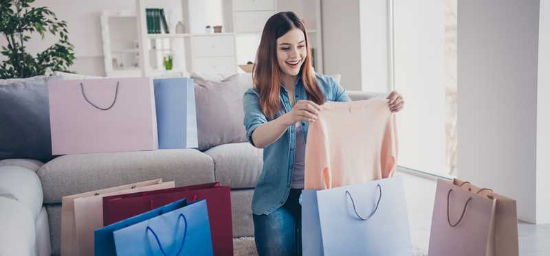 Person opening shopping bags of clothing.