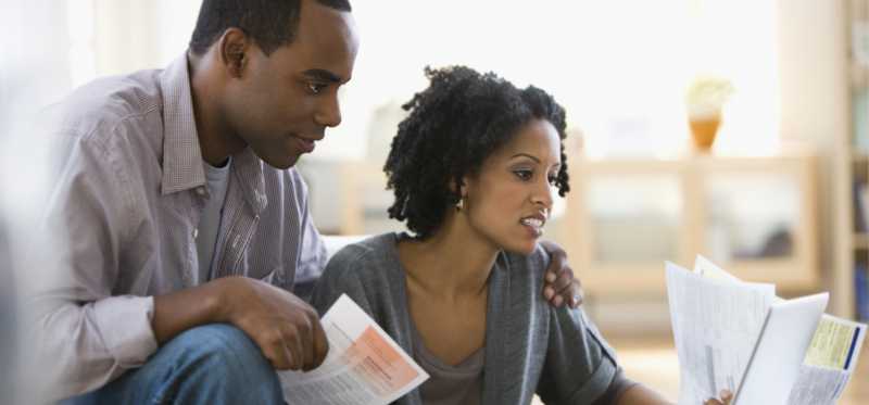 Two people looking over finances on laptop.