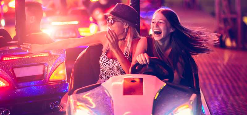 Two people a in bumper car at an amusement park.