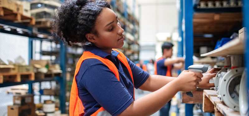 Warehouse worker scanning items with bar code reader