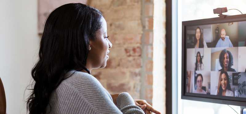 Person sitting in home office and attending virtual meeting.