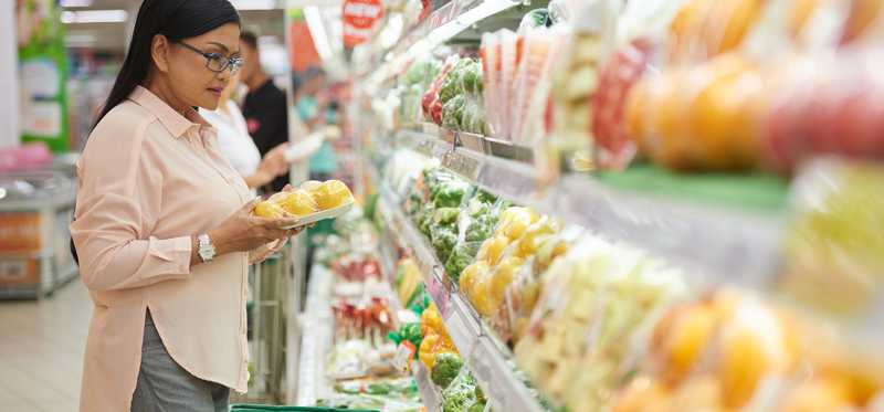 Person in grocery store looking at produce.