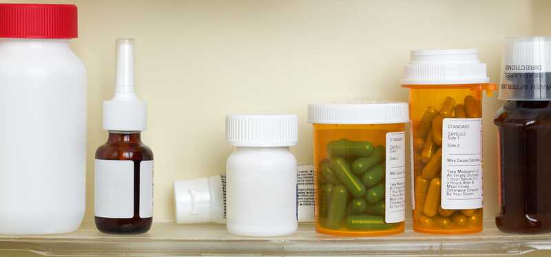 Bottles of prescription medicine sitting on shelves in cabinet