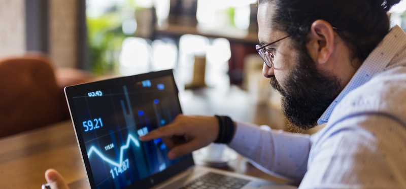 Person tracking stock movements on computer screen.