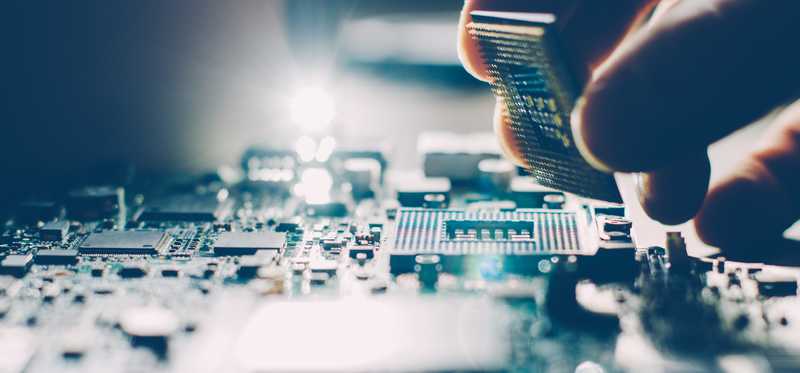 Someone building processor holding computer microchip.