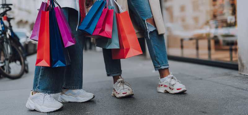 Two people shopping with colorful bags in hand.