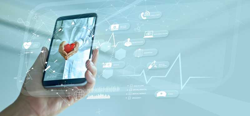 Person holding mobile phone with image of doctor holding heart representing digital medicine.