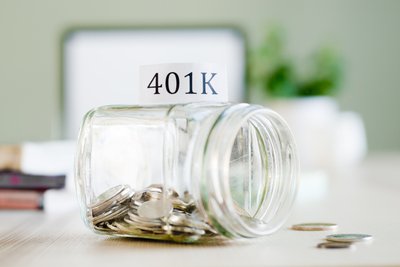 A glass jar with coins and sign reading 401k in the background.