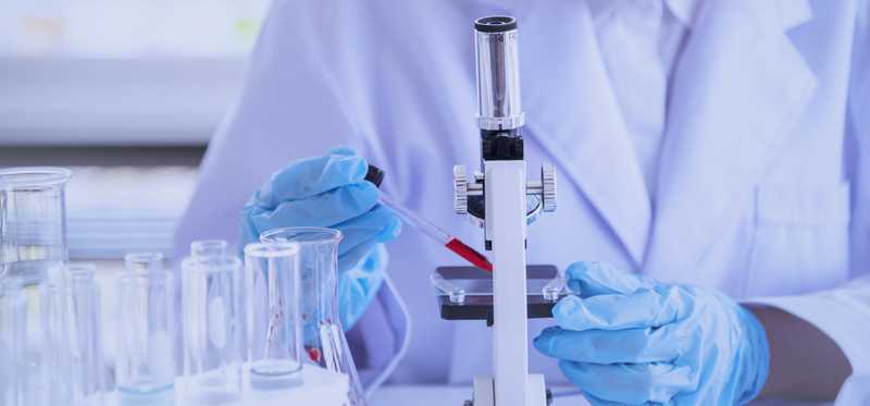 Lab worker placing sample under microscope