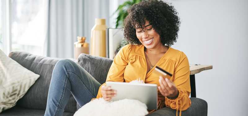 Smiling woman in her living room getting ready to make online purchase