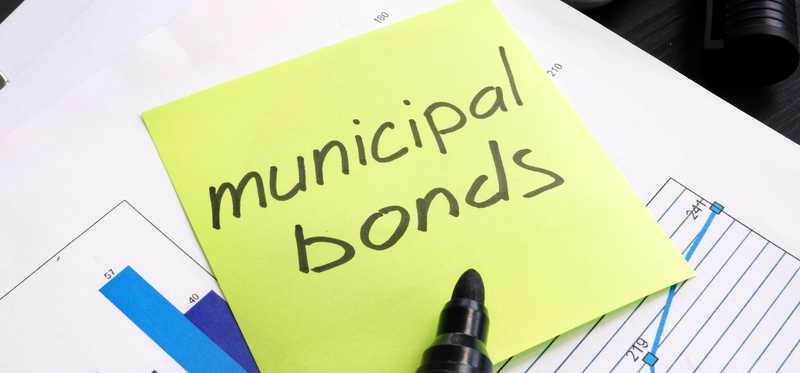 Municipal Bond written on a sticky note and documents.