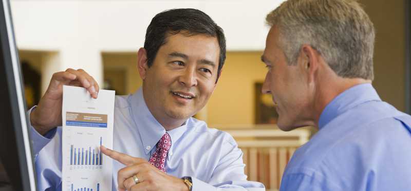Two businesspeople reviewing growth charts.