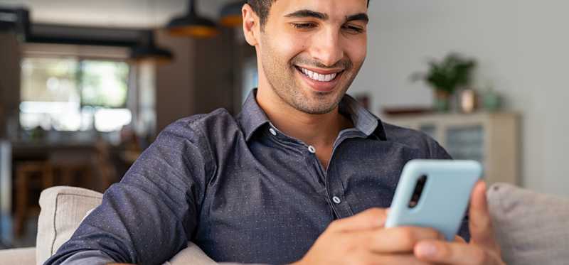 Young man smiling looking at smartphone