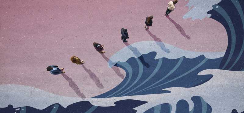 Line of people near waves painting on ground as seen from above.