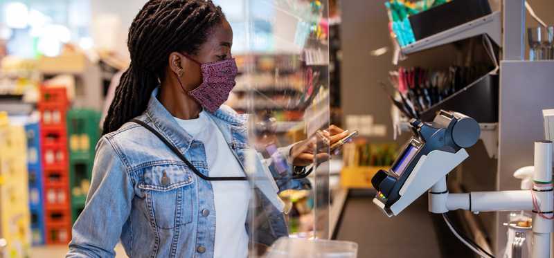 Masked person checking out at store.