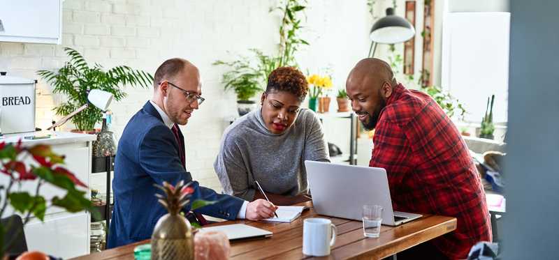 Couple sitting with their financial advisor in a sunny room