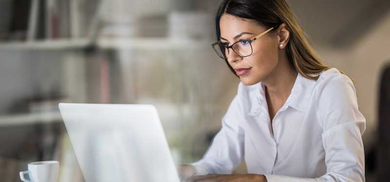 Person wearing glasses while looking at laptop.
