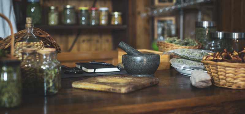 Counter of cannabis dispensary with mortar and pestle, jars, and notebook